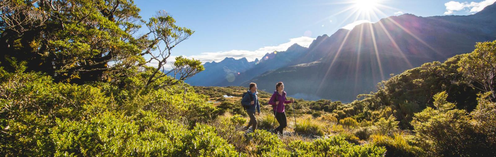 An awe inspiring panoramic shot of couple hiking at sunsett.