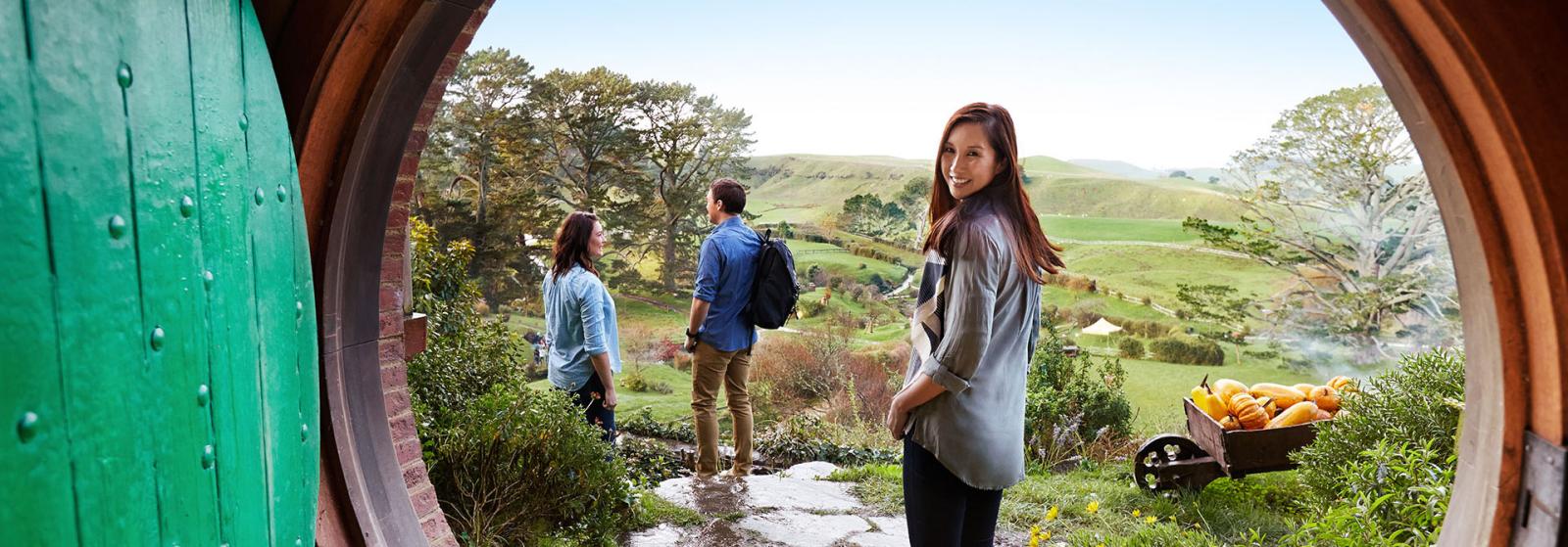 Young people a hobbit hole in middle earth New Zealand.